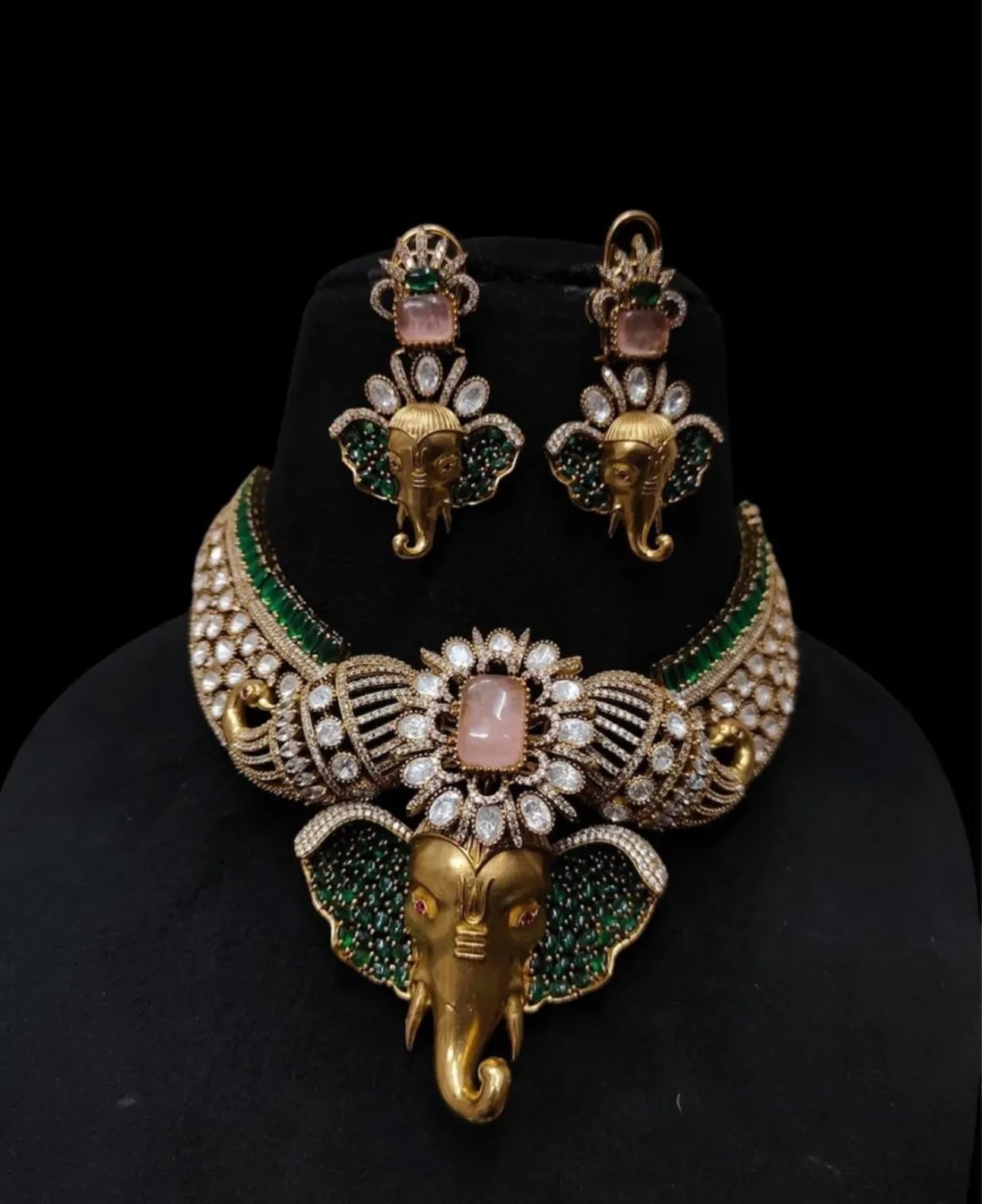 This is a traditional Indian choker necklace featuring a Ganesha pendant, studded with pink, emeralds, and diamonds.