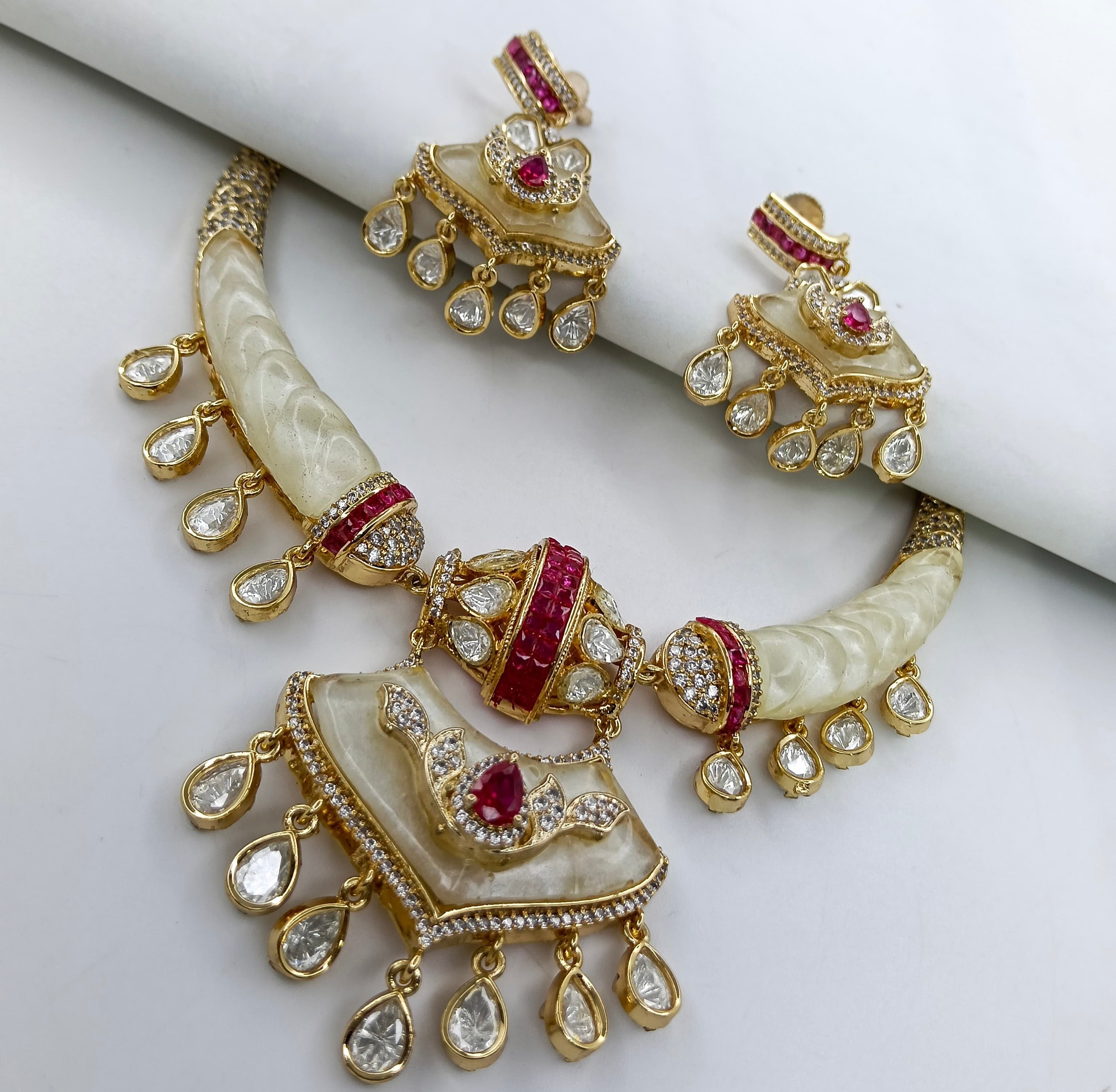This is a Moissanite Ruby Kundan Hasli Necklace Set with matching earrings.