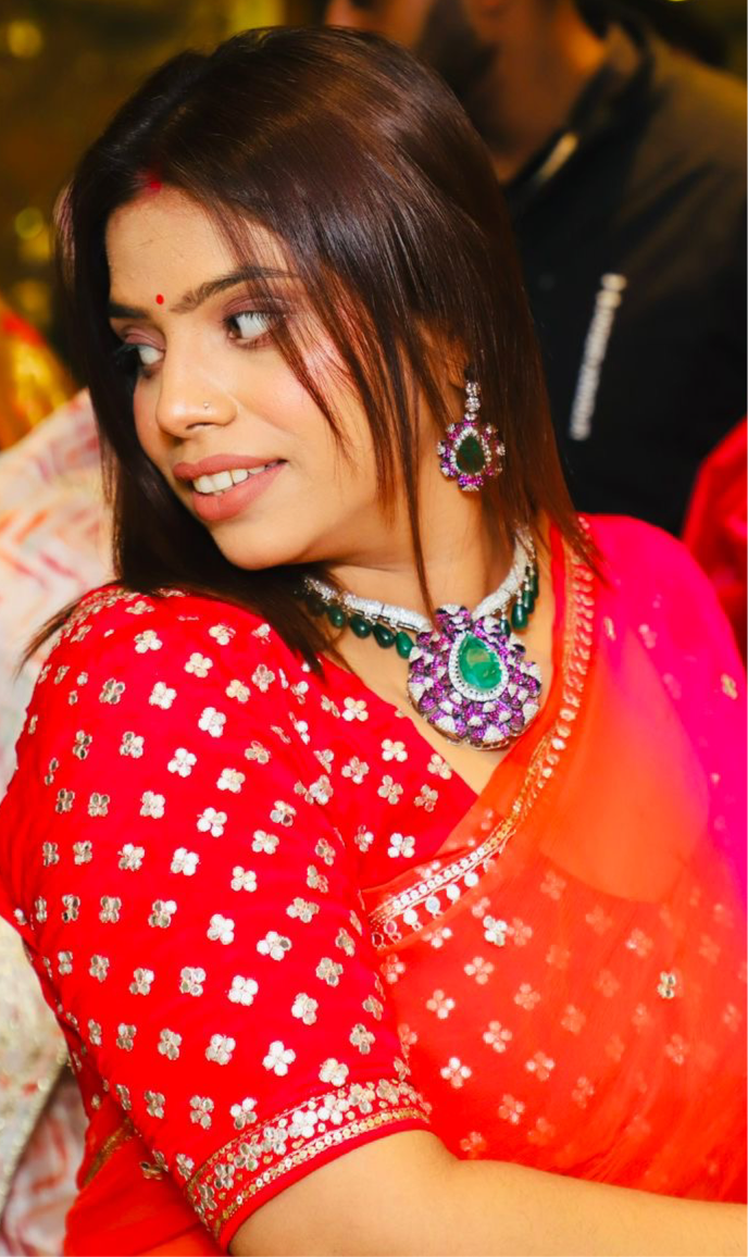 A gorgeous necklace and earring set! The green and magenta color combination is striking, with a royal vibe. The central pendant features a large green stone surrounded by intricate pink and white designs, complemented by matching earrings.