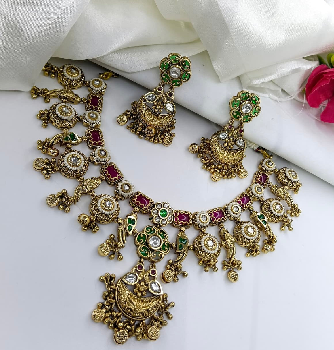 This is a gold-plated peacock design antique necklace and earring set with ruby and emerald-like stones.