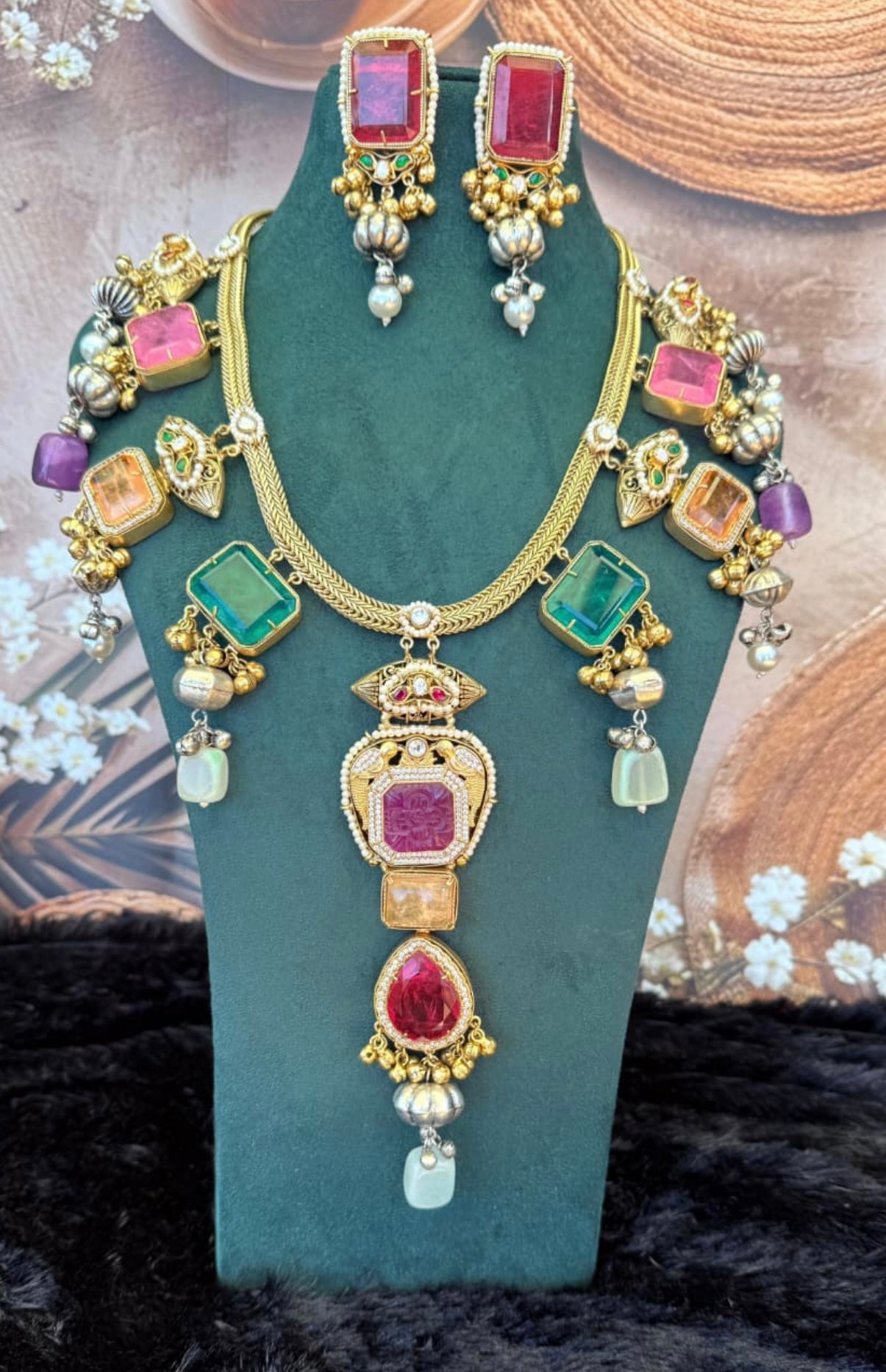 This is a Kundan necklace set with multicolored stones and pearl drops