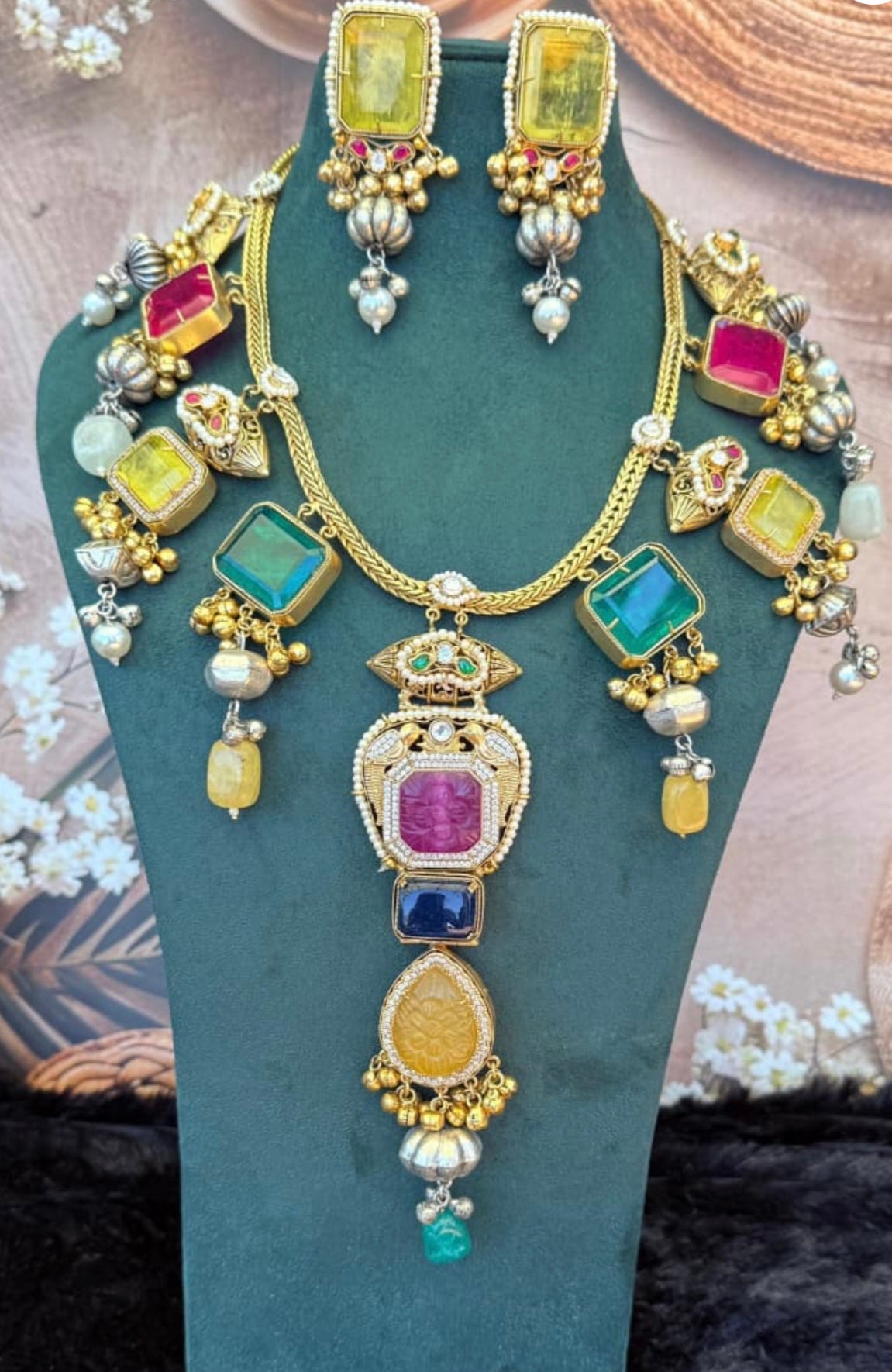 This is a Kundan necklace set with multicolored stones and pearl drops.