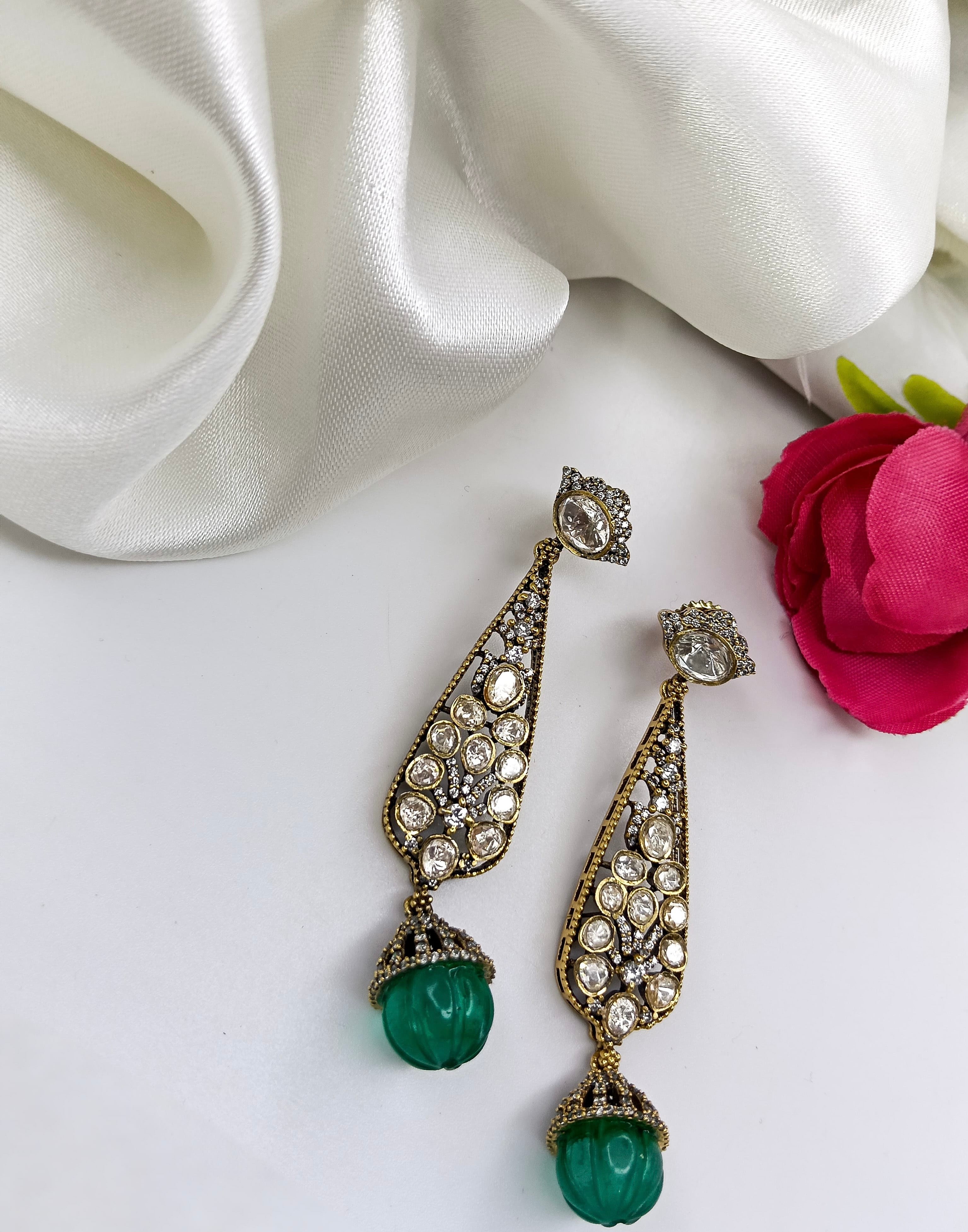 This is a pair of Polki earrings with an emerald drop
