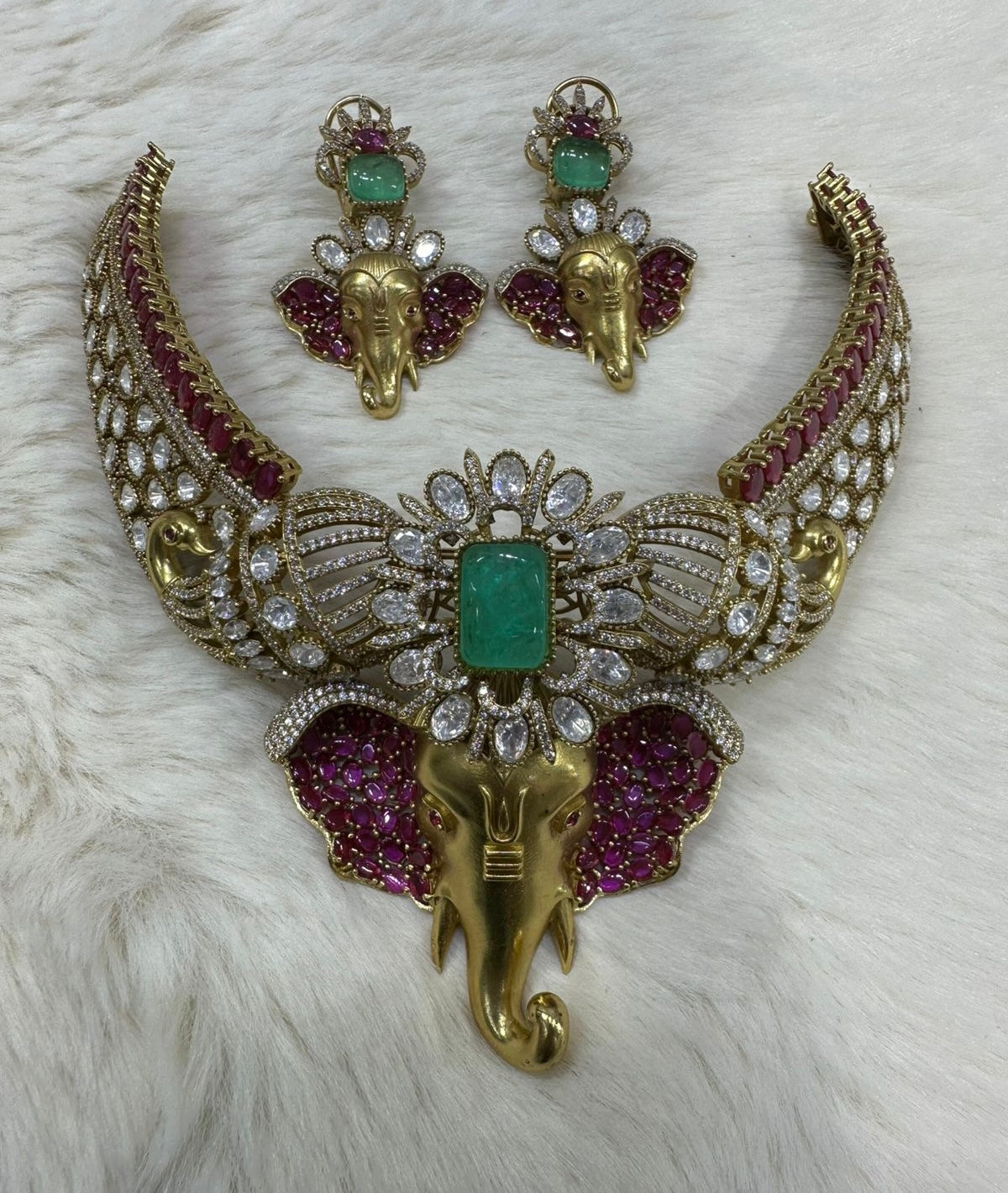 This is a traditional Indian choker necklace featuring a Ganesha pendant, studded with rubies, emeralds, and diamonds.