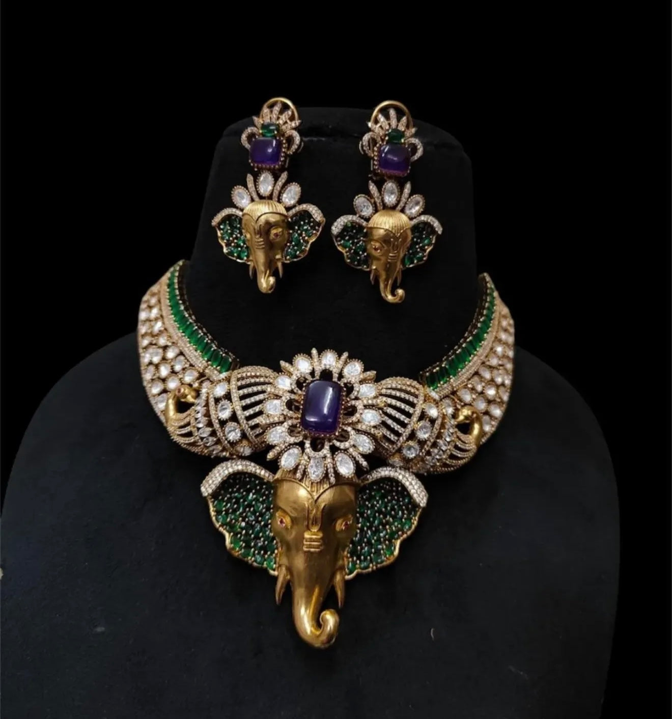 This is a traditional Indian choker necklace featuring a Ganesha pendant, studded with purple ,emeralds, and diamonds.