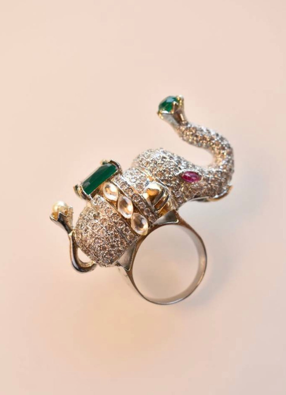 diamond designer elephant ring with a green gemstone.