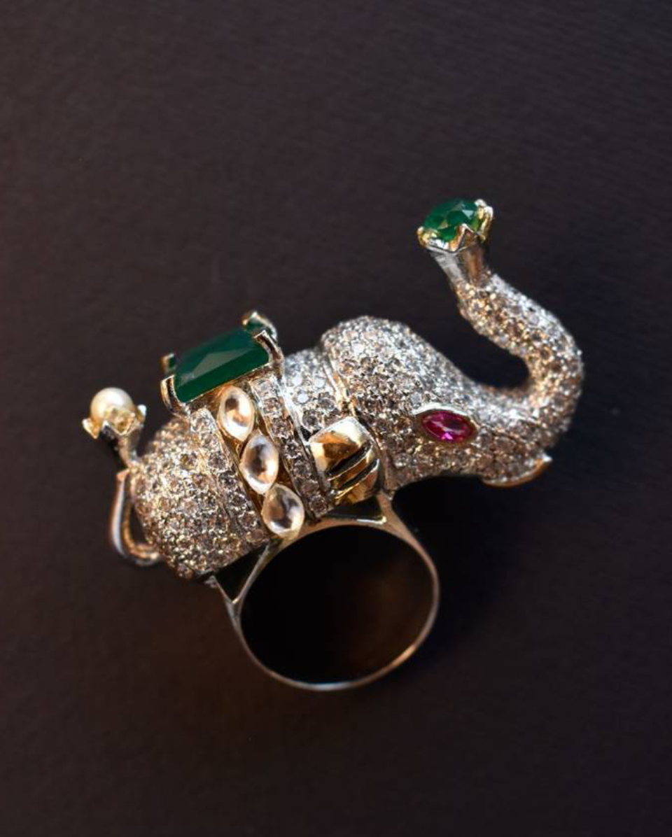 diamond designer elephant ring with a green gemstone.